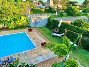a backyard with a swimming pool and a garden at Pousada Manaaki in Búzios