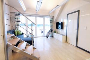 ein Wohnzimmer mit einer Treppe und einer Couch in der Unterkunft Apartament Golf & Lake in Kalinowo