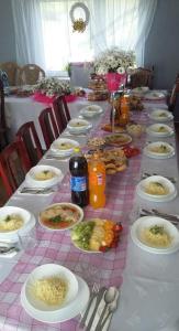 długi stół z talerzami żywności w obiekcie Domek na skraju lasu w mieście Dąbrowa Górna