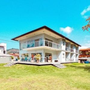 uma grande casa branca com um grande quintal em Pousada Cantinho da Praia em Paraty