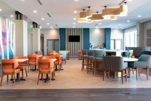 a restaurant with tables and chairs and a bar at La Quinta Inn & Suites by Wyndham San Antonio Seaworld LAFB in San Antonio +35 photos
