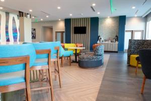 a restaurant with blue chairs and a tables and chairs at La Quinta Inn & Suites by Wyndham San Antonio Seaworld LAFB in San Antonio