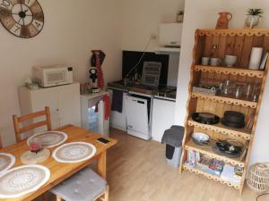 une petite cuisine avec une table en bois et une salle à manger dans l'établissement Le petit Chalet Luchonnais, à Luchon