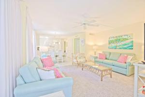 Una sala de estar con dos sofás azules y una mesa. en Island Beach Club #210A, en Sanibel