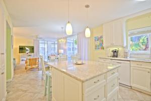 Una cocina con gabinetes blancos y una isla grande. en Island Beach Club #210A, en Sanibel