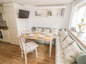 a living room with a table and a couch at Chapel Cottage in Pewsey
