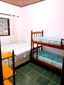 a room with two bunk beds and a window at Recanto dos Cafezais in Bueno Brandão