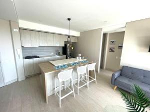 cocina y sala de estar con encimera y taburetes en Confortable y exclusivo apartamento en Martinique Cielo Mar, en Cartagena de Indias