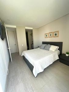 1 dormitorio con 1 cama y TV de pantalla plana en Confortable y exclusivo apartamento en Martinique Cielo Mar, en Cartagena de Indias