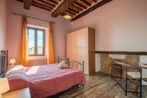 una camera con letto, scrivania e finestra di Apartment Poggiolo a Montepulciano