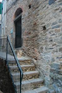 a stone building with stairs next to a window at Il Soppalco in Corniglia