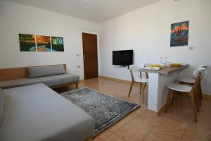 uma sala de estar com uma cama, uma mesa e uma televisão em Rondine Studio Apartment em Tirana