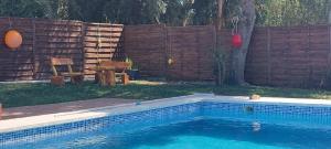 una piscina en un patio trasero con una valla de madera en Finca Esmeralda en Zahora