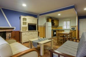 eine Küche und ein Wohnzimmer mit einem Sofa und einem Tisch in der Unterkunft Hotel y Apartamentos La Lonja in Cangas de Onís
