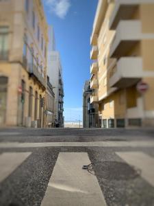 an empty street in a city with tall buildings at Foz Relógio Apartment in Figueira da Foz