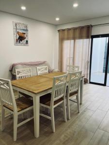 - une salle à manger avec une table et des chaises en bois dans l'établissement Casa Marta e Casa Francisco, à Olhão