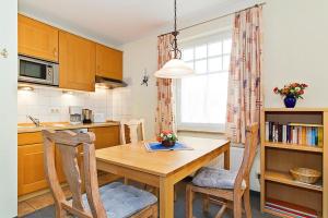 a kitchen with a wooden table and two chairs at Ostseewelle Ostseewelle 009 in Kühlungsborn