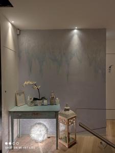 una stanza con tavolo e parete con quadro di Albero della vita a Spotorno