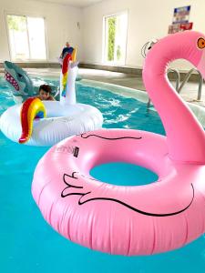 a child is riding on an inflatable flamingo in a pool at Ocean Acres Ogunquit in Ogunquit