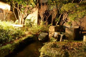 un giardino con un ruscello di acqua e alberi di Guesthouse giwa - Vacation STAY 23190v a Mishima