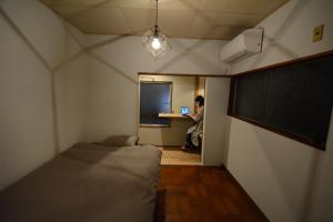 una camera con due letti e una persona che lavora su un computer portatile di Guesthouse giwa - Vacation STAY 23190v a Mishima