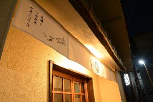 un edificio con una finestra e un cartello sopra di Guesthouse giwa - Vacation STAY 23190v a Mishima