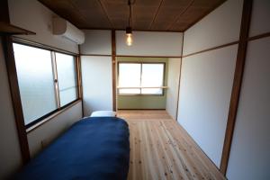 a small room with a bed and two windows at Guesthouse giwa - Vacation STAY 14269v in Mishima