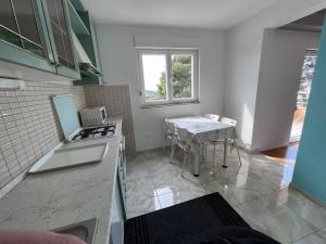 uma cozinha com um fogão e uma mesa em Apartment Popeye em Makarska