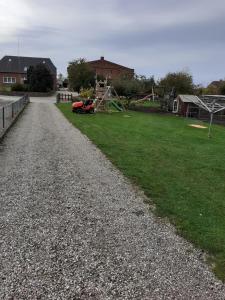 a gravel driveway with a playground in a yard at Blick zur "Orther Bucht" in Teschendorf