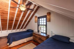 a bedroom with two beds and a ceiling fan at Athena's Mahogany House and The PoolClub at Mahogany Bay! in San Pedro +52 photos