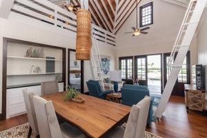 a dining room with a wooden table and chairs at Athena's Mahogany House and The PoolClub at Mahogany Bay! in San Pedro