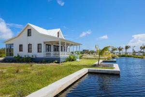 a white house with a canal in front of it at Athena's Mahogany House and The PoolClub at Mahogany Bay! in San Pedro