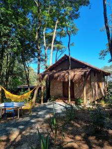 a hut with a hammock in front of it at Chalé Rústico 3 - Retiro Andaluz in Brumadinho