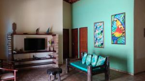 a living room with two chairs and a tv at casa na praia de guajiru in Guajiru