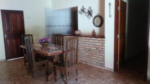 uma sala de jantar com uma mesa e uma parede de tijolos em casa na praia de guajiru em Guajiru