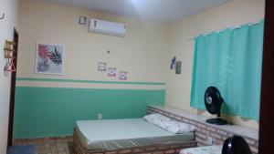 a room with a bed and a window with blue curtains at casa na praia de guajiru in Guajiru +31 photos