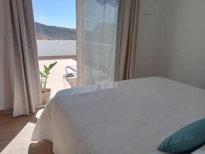 a bedroom with a bed and a window with a view at Apartamento Onix Jacuzzi in Tarajalejo