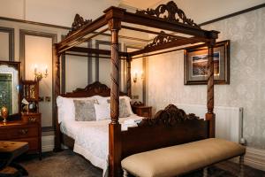 The Queens Hotel في ليثام سانت أنيه: غرفة نوم مع سرير بأربعة أعمدة
