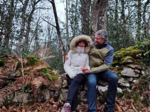 un hombre y una mujer sentados en una roca en el bosque en Gîte Dagueloire en La Daguenière