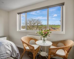 um quarto com uma mesa e cadeiras e uma janela em Maya residence em Bourne End