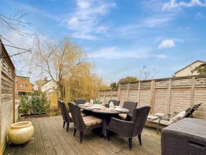a patio with a table and chairs on a deck at Maya residence in Bourne End