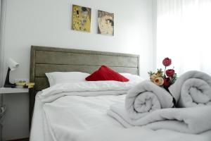 a bed with white sheets and towels on it at Suncokret Apartmani Loznica in Loznica