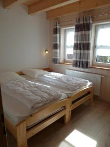 łóżko w pokoju z 2 oknami w obiekcie Ferienhaus Nr 17A3, Feriendorf Hagbügerl, Bayr Wald w mieście Waldmünchen