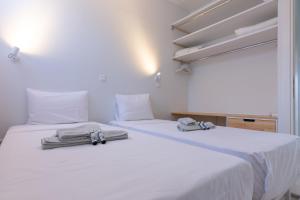 two beds in a room with white sheets and towels at Casa Horizon in Porto Heli +59 photos