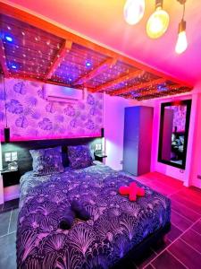 a bedroom with a purple bed with a red dog on it at Aux Bulles in Limoges