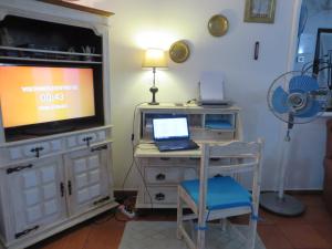 a room with a desk with a laptop and a tv at Villa El Alcazar in Carvoeiro