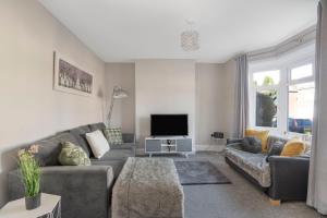 a living room with a couch and a tv at Spacious 3 Bed House, Netflix, Garden, Parking in Southampton