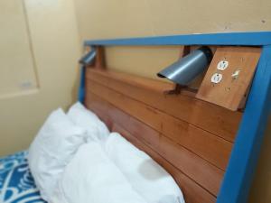 a bed with a blue head board and a lamp at Casa Benjamin Linder in Managua