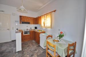 a kitchen with wooden cabinets and a table with a vase on it at Miranda Haus in Arillas +65 photos
