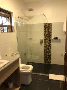 a bathroom with a toilet and a glass shower at Jey's Jiko Kitchen and Resort in Muhoroni